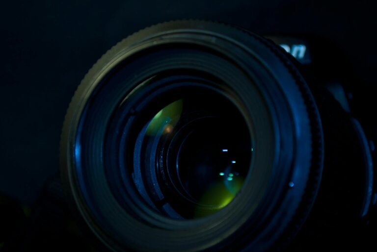 Detailed close-up of a camera lens reflecting light, showcasing advanced optics.
